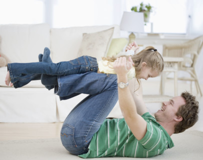 Father and daughter playing on floor. Date : 2007
