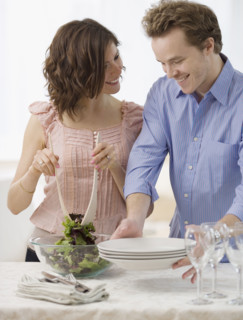 Couple setting table and tossing salad. Date : 2007