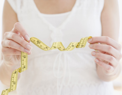 Woman holding curled tape measure. Date : 2007
