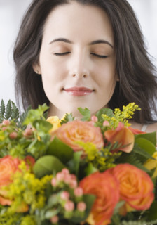 Woman smelling bouquet of flowers. Date : 2007