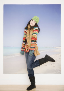 Woman in winter clothing in front of beach picture. Date : 2007