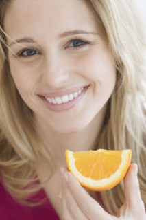 Close up of woman holding orange wedge. Date : 2007