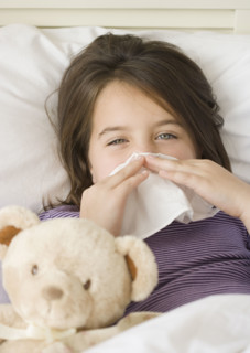 Close up of girl blowing nose in bed. Date : 2006