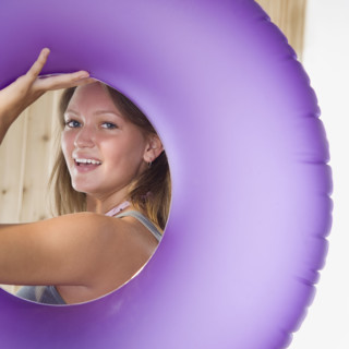 Young woman smiling through middle of inner tube. Date : 2006