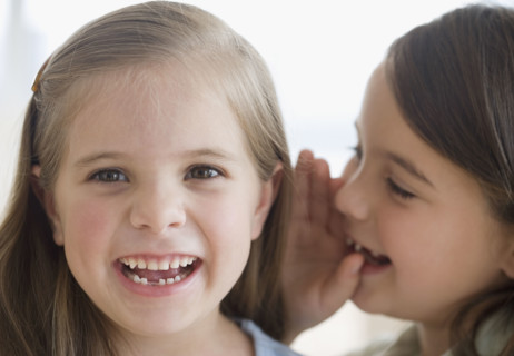 Close up of sisters telling secret. Date : 2006
