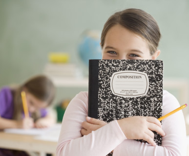 Girl holding notebook in front of face. Date : 2006