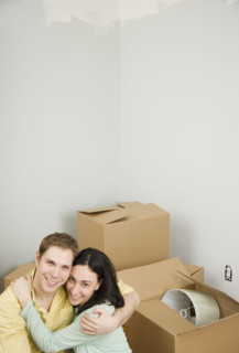 Couple hugging next to boxes in new house. Date : 2006