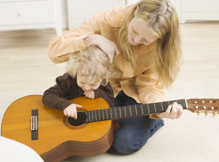 Mother and child playing with guitar. Date : 2006
