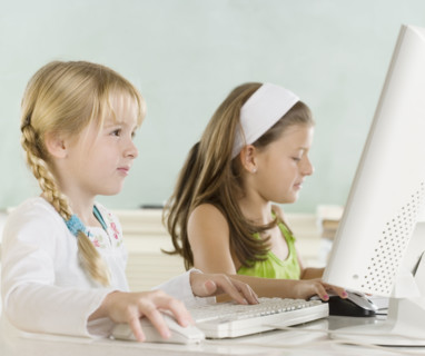 Two young girls using computers. Date : 2006