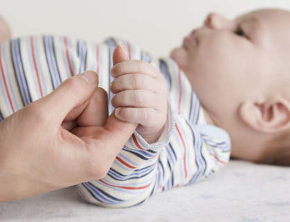 Close up of baby holding mother’s hand. Date : 2006