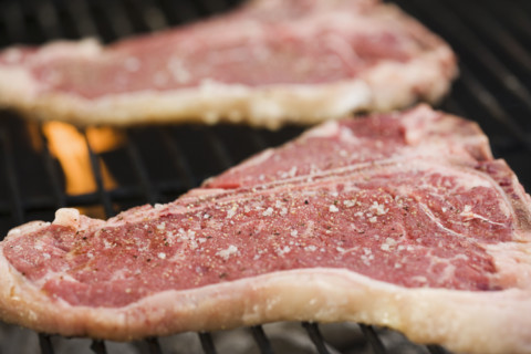 Grilling steaks outdoors. Date : 2006