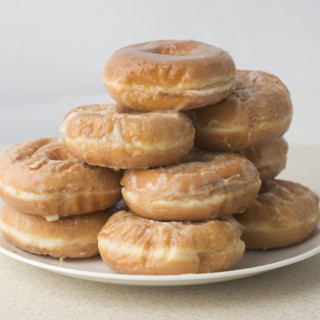 Pile of glazed donuts on plate. Date : 2006
