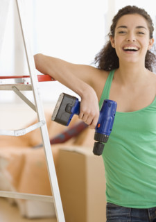 Woman holding cordless drill. Date : 2007