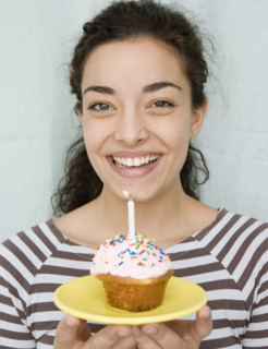 Woman holding cupcake with candle. Date : 2007