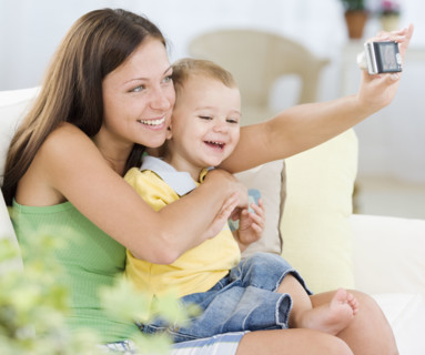 Mother taking own photograph with baby. Date : 2007