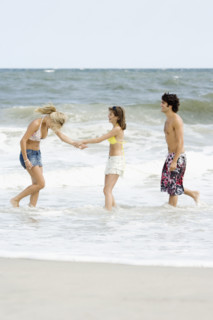 Friends standing in ocean surf. Date : 2007