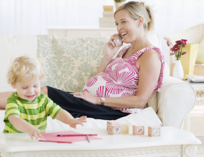 Pregnant mother talking on telephone. Date : 2007