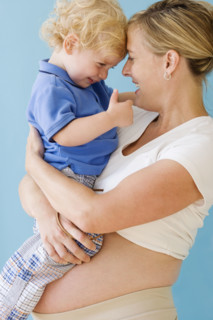 Pregnant mother hugging child. Date : 2007
