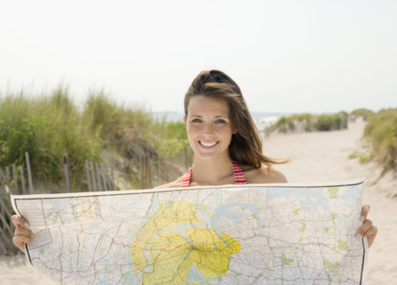 Woman holding map at beach. Date : 2007