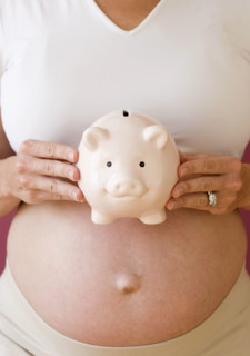 Pregnant woman holding piggy bank. Date : 2007