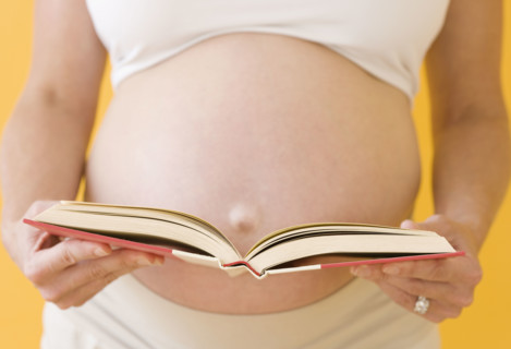 Pregnant woman holding open book. Date : 2007