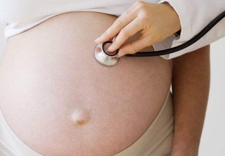 Pregnant woman with stethoscope on belly. Date : 2007