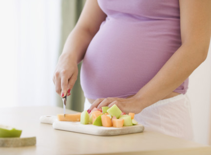 Pregnant woman chopping fruit. Date : 2007
