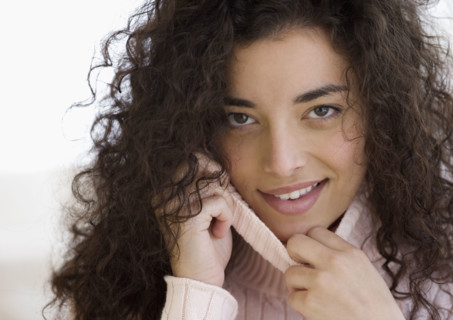 Woman pulling on neck of sweater. Date : 2007