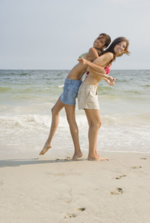 Two young women playing at beach. Date : 2007
