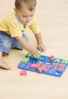 Baby playing with foam letters. Date : 2007