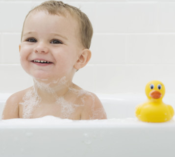Baby and rubber duck in bath. Date : 2007