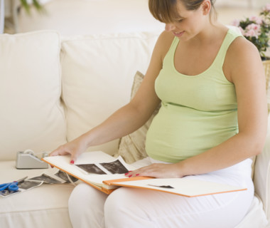 Pregnant woman putting ultrasound in photo album. Date : 2007