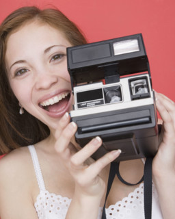 Woman holding instant camera. Date : 2007