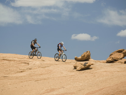 Couple riding mountain bikes in desert. Date : 2007