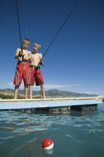 Brothers fishing off dock in lake, Utah, United States. Date : 2007