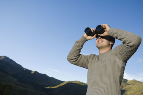 Man looking through binoculars, Utah, United States. Date : 2007