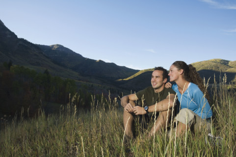 Couple sitting on hillside, Utah, United States. Date : 2007