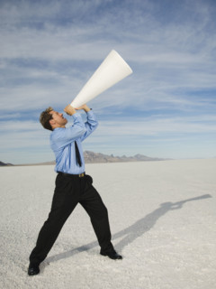 Businessman yelling into megaphone, Salt Flats, Utah, United States. Date : 2007