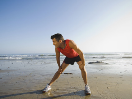 Man stretching at beach. Date : 2007