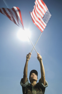Female army soldier holding American flags. Date : 2007