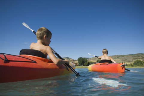 Brothers paddling in canoes on lake, Utah, United States. Date : 2007