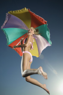 Woman jumping with beach umbrella. Date : 2007
