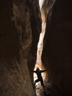 Woman looking up between rock formations. Date : 2007