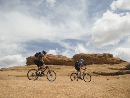 Couple riding mountain bikes in desert. Date : 2007