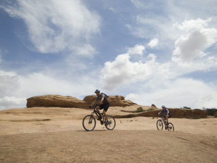 Couple riding mountain bikes in desert. Date : 2007