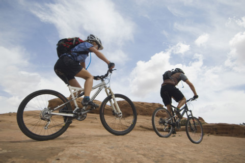 Couple riding mountain bikes in desert. Date : 2007