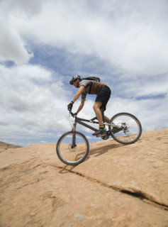 Man riding mountain bike on rock formation. Date : 2007