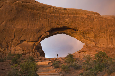 People standing under rock formation. Date : 2007