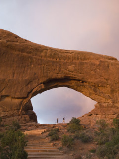 People standing under rock formation. Date : 2007