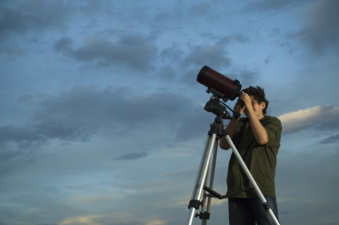 Man using telescope on tripod. Date : 2007